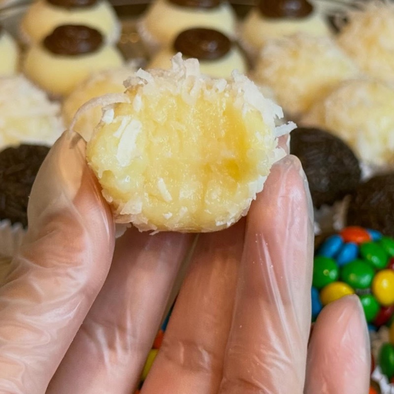 Coconut brigadeiro with a bite showing the creamy center