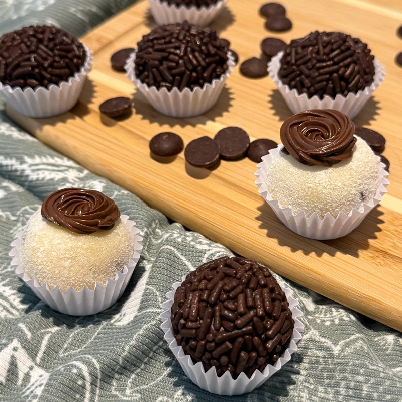 Assorted brigadeiros arranged on a wooden board